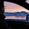 a man driving a car on a snowy road